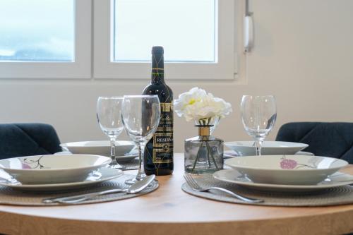 a table with a bottle of wine and glasses on it at Apartman Hills in Split