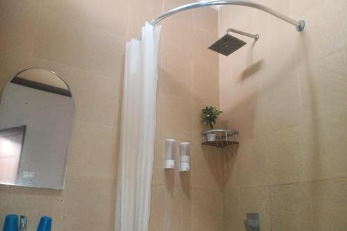 a shower with a shower curtain in a bathroom at Aryani Suites Syariah in Jakarta