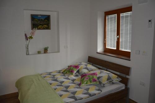 a small bed in a bedroom with a window at Apartmaji Kobal in Zoll