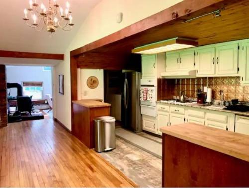 una cucina con armadi bianchi e frigorifero in acciaio inossidabile di INCREDIBLE Northern Westchester Historic Hideaway a South Salem