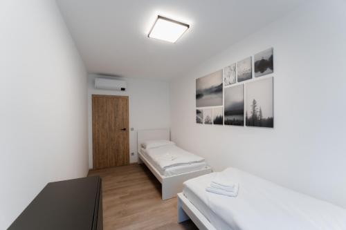 a white room with two beds and a window at Mlýn Herlíkovice in Hořejší Vrchlabí