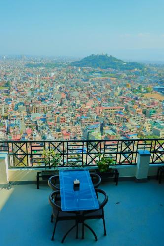 a blue table and chairs on a balcony with a view at Skyline Restaurant & Bar in Kathmandu