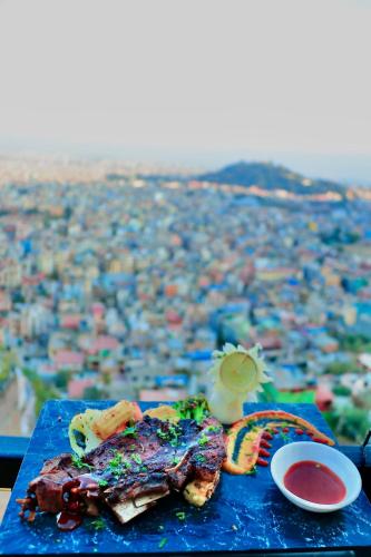 un plato azul de comida con vistas a la ciudad en Skyline Restaurant & Bar en Katmandú