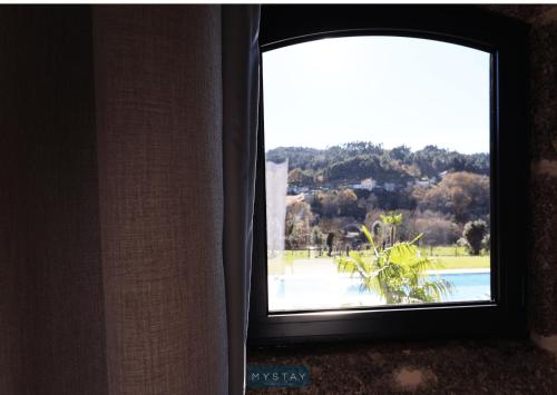 a window in a room with a view of a pool at MyStay - Casa d'Henrique in Vieira do Minho