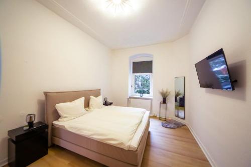 a bedroom with a bed and a flat screen tv at Massagesessel, King-Sized Bed, Billardtisch, 2 Couches in Berlin