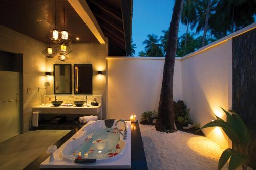 ein Badezimmer mit einer Badewanne und einem Waschbecken in der Unterkunft Atmosphere Kanifushi - Premium All Inclusive with Free Transfers in Lhaviyani Atoll