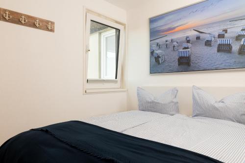 um quarto com uma cama e uma fotografia na parede em Meeresrauschen Sierksdorf em Sierksdorf
