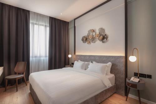 a bedroom with a large white bed and a window at FUHOTEL in Bukit Mertajam