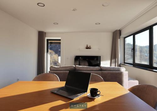 a laptop sitting on a wooden table in a living room at MyStay - Casa d'Henrique in Vieira do Minho