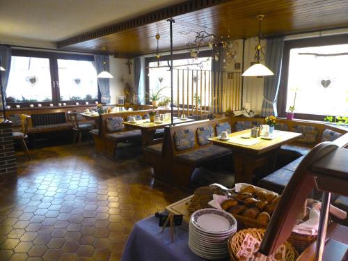 a restaurant with tables and couches in a room at Pension Gasthof Zum Lamm in Bischofsheim an der Rhön