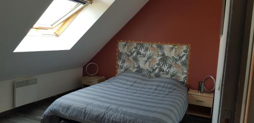 une chambre avec un lit dans un grenier dans l'établissement maison privative la fougere, à La Haye-dʼEctot