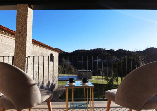 two chairs and a table on a balcony with a view at MyStay - Casa d'Henrique in Vieira do Minho
