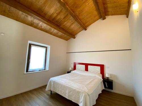 a bedroom with a red bed and a window at Levante Flat - 100 m from the beach in Fano