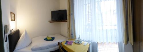 um quarto com uma cama, uma mesa e uma janela em Pension Gasthof Zum Lamm em Bischofsheim an der Rhön