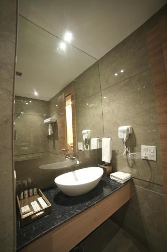 a bathroom with a sink and a large mirror at ANTILIA BY ZION in Sonīpat
