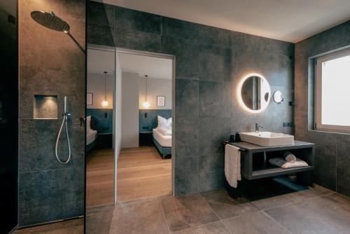 a bathroom with a shower and a sink and a mirror at LA LIBELLA - slow living Suites in Merano