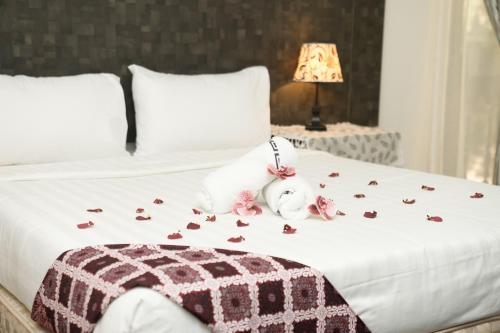 a bed with roses on it with a stuffed animal on it at Putera Island Resort in Melaka