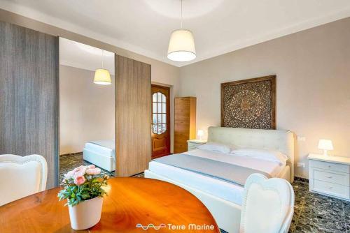 Un dormitorio con una cama y una mesa con flores. en Il Giardino delle Meraviglie, en Le Grazie