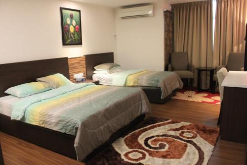 a bedroom with two beds and a living room at Adha Studio & Suite Kota Bharu in Kota Bharu