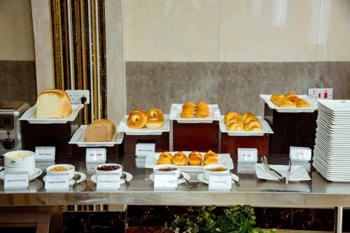 a buffet line with various types of bread and pastries at Tiffany Diamond Hotels LTD - Makunganya in Dar es Salaam