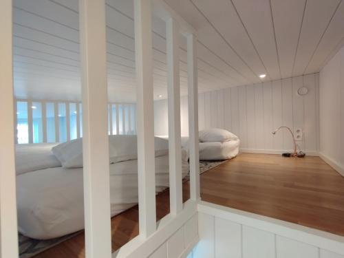 a bedroom with two beds with white walls and wood floors at Bålsta Studio Houses in Bålsta