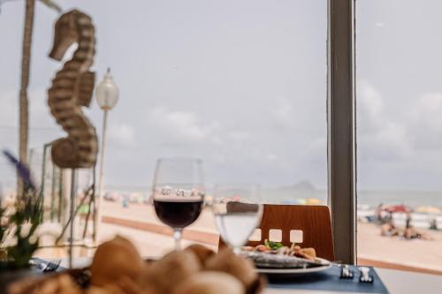 a table with a plate of food and a glass of wine at Hotel Apartamentos Londres La Manga in La Manga del Mar Menor