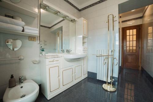uma casa de banho branca com um lavatório e um WC em Neblou em Aosta