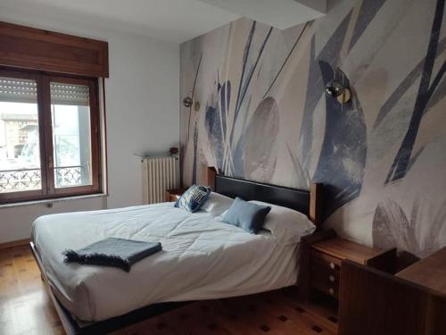 um quarto com uma cama com uma grande pintura na parede em Neblou em Aosta