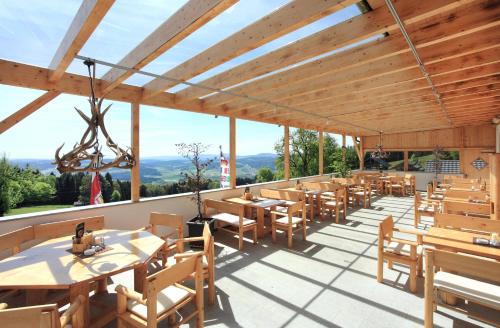 a restaurant with wooden tables and wooden chairs at Landhotel Haagerhof in Aigen im Mühlkreis
