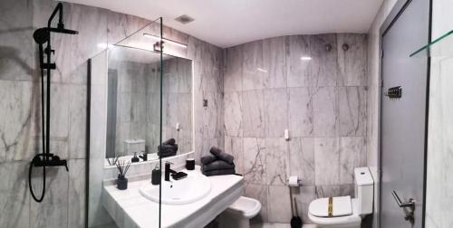 a bathroom with a sink and a toilet and a shower at Parque Botanico Resort in Estepona