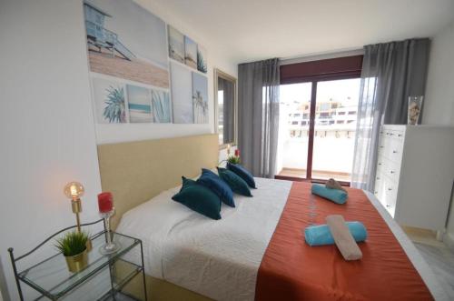 a bedroom with a large bed with blue pillows at Parque Botanico Resort in Estepona