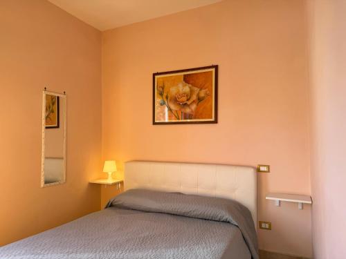 ein Schlafzimmer mit einem Bett und einem Bild an der Wand in der Unterkunft Villa Paeonia in Paestum