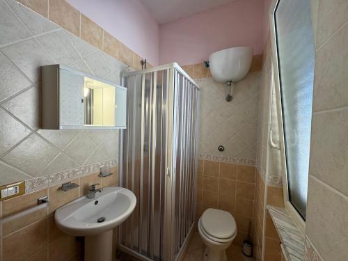 ein Badezimmer mit einem Waschbecken, einem WC und einem Spiegel in der Unterkunft Villa Paeonia in Paestum