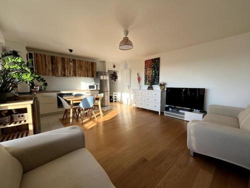 een woonkamer met een bank en een tafel en een keuken bij Location for Olympic Games (JO) in Houilles