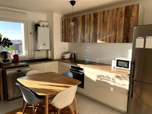 une cuisine avec une table en bois, une table et des chaises dans l'établissement Location for Olympic Games (JO), à Houilles