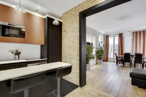 une cuisine avec une grande porte en verre menant à une salle à manger dans l'établissement Bastille - Gare de Lyon - Appartement familial, à Paris