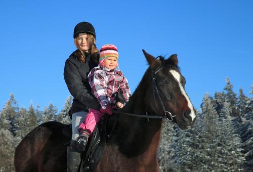 a woman and a child riding on a horse at Landhotel Haagerhof in Aigen im Mühlkreis