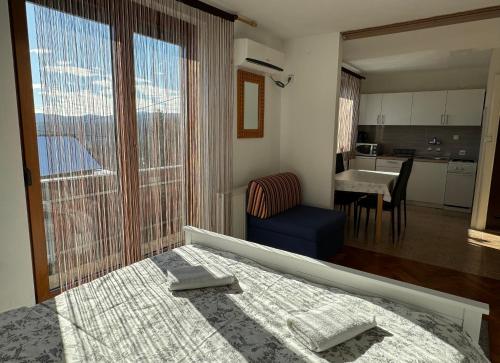 um quarto com uma cama e uma grande janela em Guest House Aurora em Poljanak