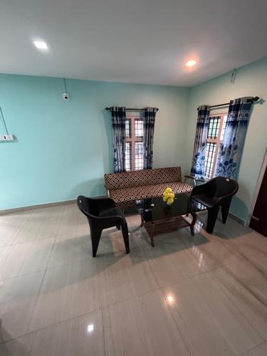 a living room with a couch and chairs at Namasthe Inn AC, Ottapalam-Palakkad Highway, Lakkidi in Ottappālam