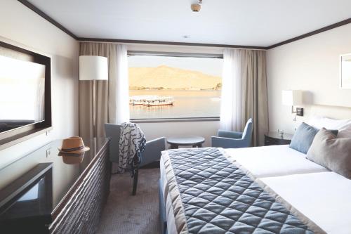 a hotel room with a bed and a window at Jaz Imperial Nile Imperial Cruise - Every Thursday from Luxor- Aswan- Luxor for 07 Nights in Luxor
