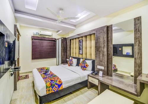 ein Schlafzimmer mit einem Bett und einem Schreibtisch. in der Unterkunft Prashant Hotel Indore in Indore