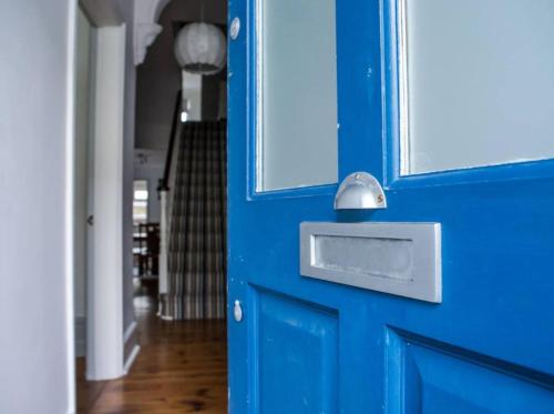 Una puerta azul con un buzón plateado. en The Blue House, en Worthing