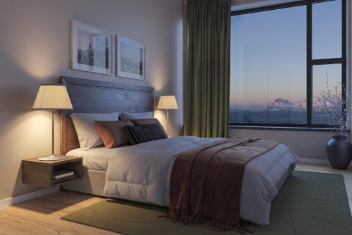 a bedroom with a large bed and a large window at Wood Hotel Bodø in Bodø