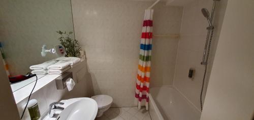 a bathroom with a shower and a toilet and a sink at Solitaire Hotel in Berlin