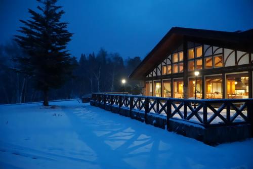 a log cabin in the snow at night at WHITE HOTEL GRAND HAKUBA in Omachi