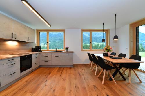 a kitchen with a wooden table and chairs in a room at Straußberghof in Riezlern