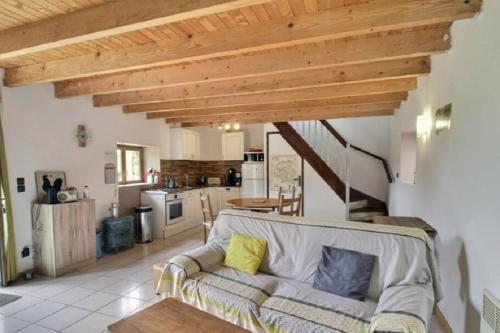 uma sala de estar com um sofá e uma cozinha em La Clef des Champs, gîte à la ferme au pied des vignes, Finistère sud ! em Pouldergat