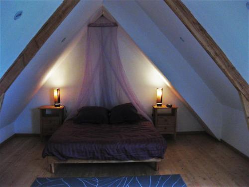 um quarto com uma cama e duas mesas de cabeceira com candeeiros em La Clef des Champs, gîte à la ferme au pied des vignes, Finistère sud ! em Pouldergat