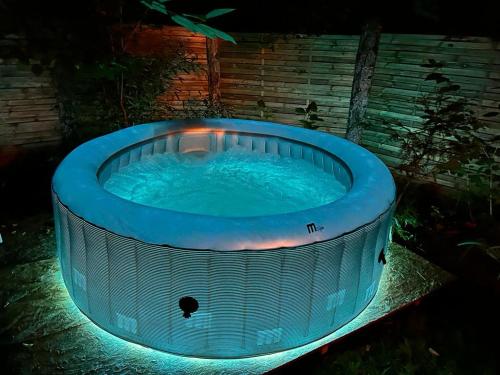 a large hot tub in a backyard at night at Chalet Privé Cosy in Malaussène