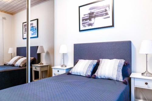 ein Schlafzimmer mit einem blauen Bett und einem Spiegel in der Unterkunft Tähtisara A - Ulkoporeammeella lisämaksullinen in Kalajoki